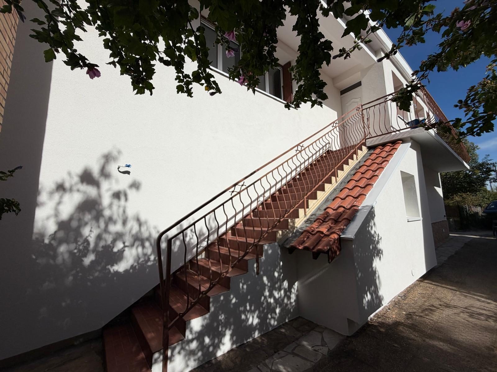 Escalier extérieur en brique et façade blanche après isolation par l'extérieur, Toulouse