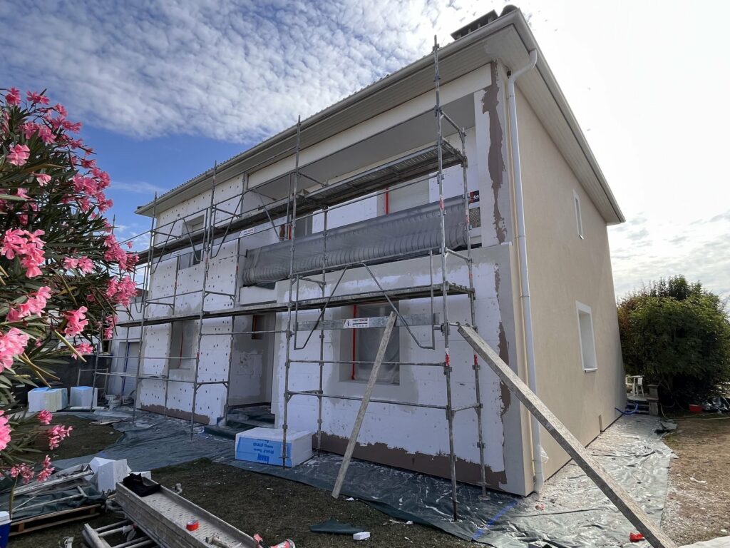 Enduit de finition en cours sur une maison à balcon