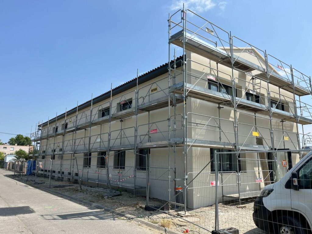 Échafaudage autour d'un bâtiment professionnel pendant l'isolation extérieure
