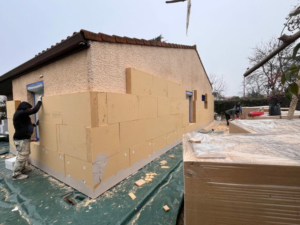 Pose de panneaux de fibre de bois sur une maison de plain-pied